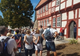 Teilnehmer eines Dorfrundgangs beim Tag des offenen Denkmals in Ditfurt vor dem historischen Rathaus, einem Fachwerkbau von 1534.